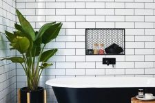 a chic bathroom with a black retro free-standing bathtub that matches the space perfectly