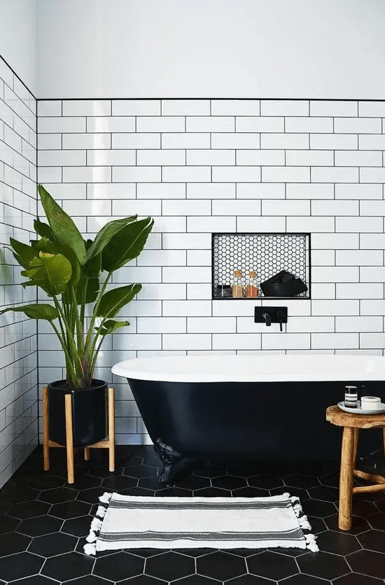 a chic bathroom with a black retro free-standing bathtub that matches the space perfectly