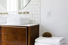 a chic mid-century modern bathroom in neutrals, with subway and hex tiles, a dark stained vanity and stool and pendant lamps