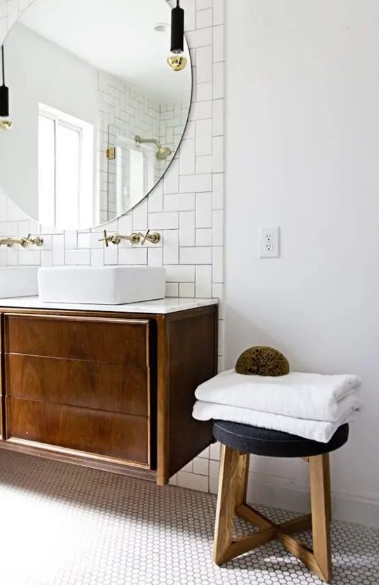 a chic mid-century modern bathroom in neutrals, with subway and hex tiles, a dark stained vanity and stool and pendant lamps