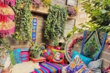a colorful boho chic terrace with bright printed textiles, hanging greenery and rattan chairs and wooden furniture