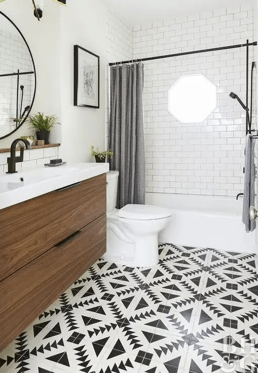 a farmhouse bathroom with a black and white tile floor, grey curtains, a floating vanity and black fixtures for a modern feel