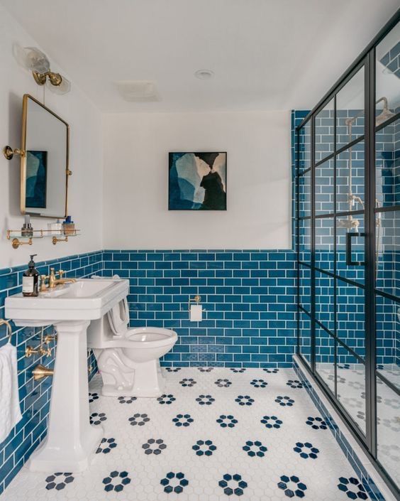 a lovely coastal bathroom with blue subway tile, a large shower space, a free-standing sink and lovely decor