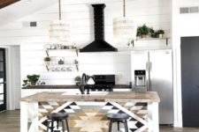 a monochromatic boho kitchen with macrame lampshades, a tribal printed kitchen island and black touches