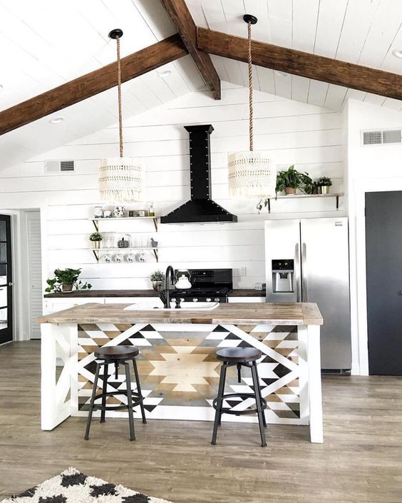 a monochromatic boho kitchen with macrame lampshades, a tribal printed kitchen island and black touches