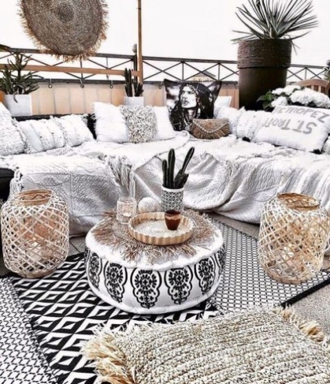 a monochromatic gypsy boho terrace done with woven lanterns, fringe textiles, baskets and potted cacti
