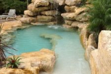 a natural pool surrounded with rocks, with a waterfall, looks like a small lagoon and is a real centerpiece of your outdoor space