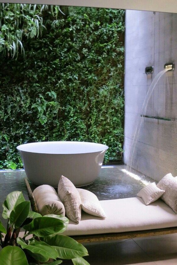 a private courtyard with a living wall, a waterfall shower and a coach by the bathtub