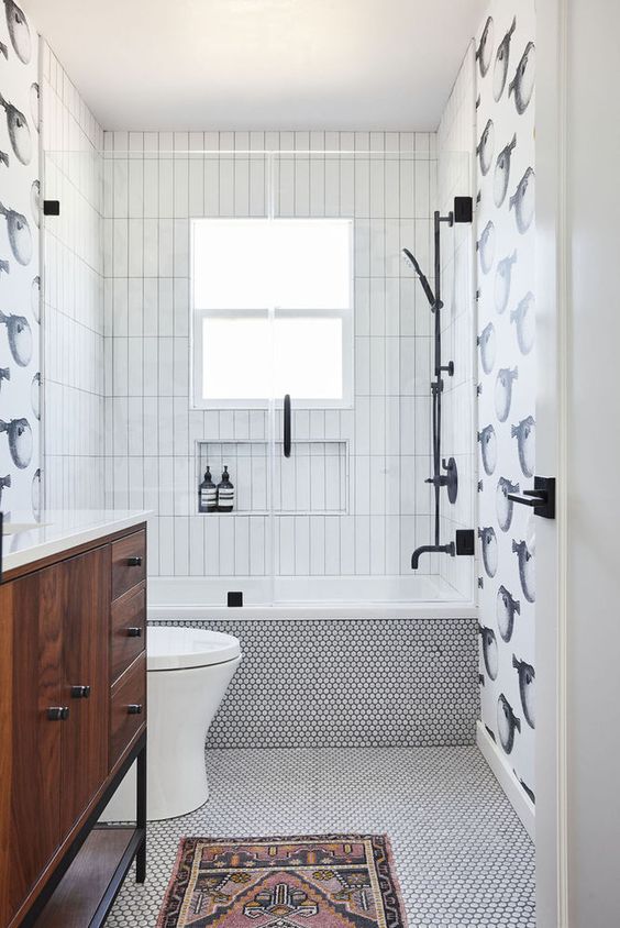 a quirky modern bathroom done with stacked, penny tiles, fish panels for an accent, a stained vanity and a bold boho rug