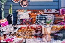 a super bright boho terrace with printed and colorful textiles, decorative baskets, lanterns and potted cacti for a desert feel