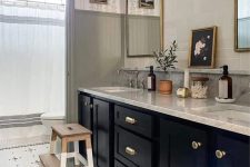 a vintage farmhouse space with wallpaper and paneling, a penny tile floor, a black vanity, mirrors and bathroom stuff