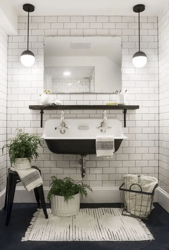 a vintage-inspired powder room in black and white, with white subway tiles with black grout