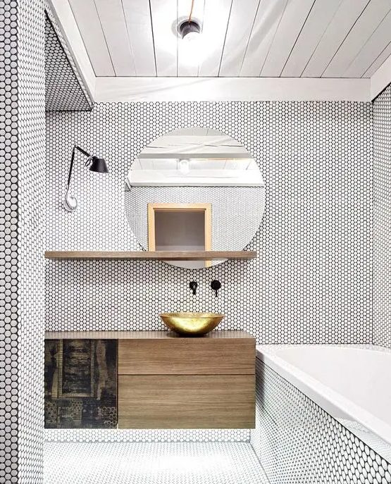 a white bathroom fully clad with penny tiles looks absolutely unique, with a stained vanity, shelf and a round mirror