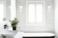 white hexagon tiles are highlighted with black grout in this minimalist bathroom