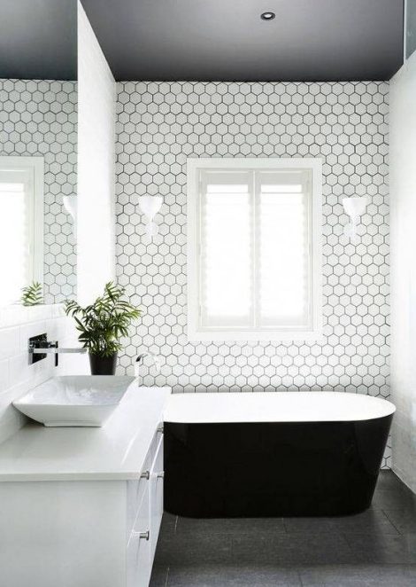 White hexagon tiles are highlighted with black grout in this minimalist bathroom