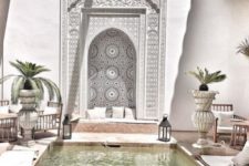 05 a bright Moroccan boho patio with amazing mosaic tiles, candle lanterns, rattan furniture, potted plants and neutral textiles