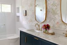 08 a beautiful bathroom with white tiles, floral wallpaper, a navy vanity and touches of gold for more chic