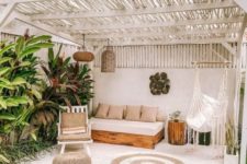 09 a welcoming boho space with a jute rug and ottoman, simple furniture, potted plants, wicker lamps and a hanging chair