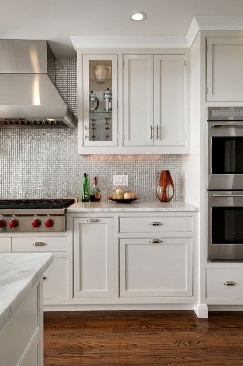 a shiny silver tile backsplash to spruce up a neutral kitchen with white cabinets