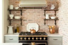 16 a small vintage-inspired kitchen with a red brick backsplash and a black retro cooker