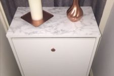 16 an IKEA Bissa hack done with copper knobs and marble contact paper is a glam idea with a trendy feel