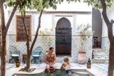 17 a Moroccan boho pool space fully clad with beautiful tiles and with potted greenery and trees growing around the pool
