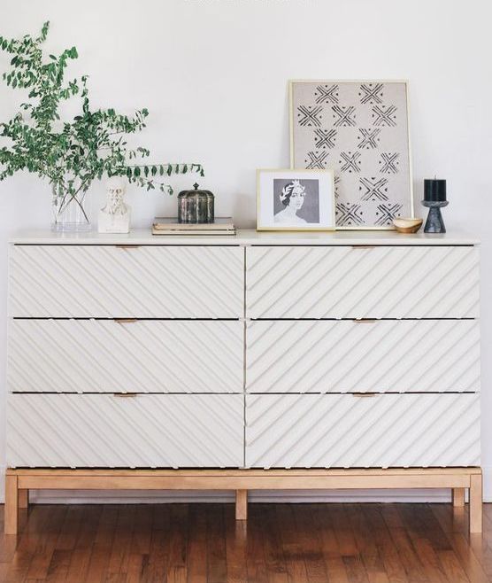 a trendy Tarva dresser hack with striped wall panels, light-colored stained legs and a frame and brass pulls