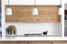 17 a white and light-colored kitchen is accentuated with a white fishscale tile backsplash