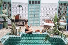 18 a bold Moroccan riad with a mosaic tile pool, potted plants and growing ones and some candle lanterns