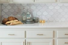 23 a chic neutral kitchen with a marble fishscale tile backsplash that make it interesting and catchy at once