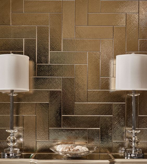 textured gold tiles set in a herringbone pattern create a sense of depth and luxury in your space