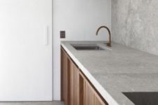 a Scandinavian kitchen with a concrete backsplash and countertop for a textural feel