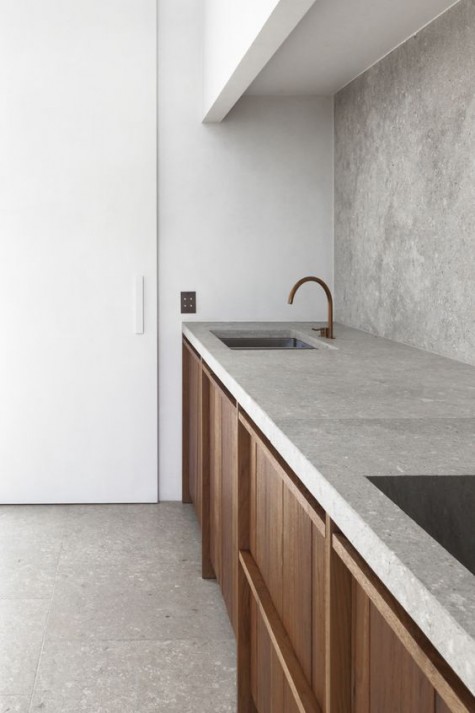 a Scandinavian kitchen with a concrete backsplash and countertop for a textural feel