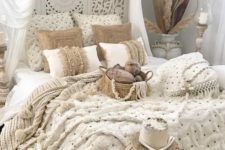 a boho Moroccan bedroom with a laser cut screen, layered fringe and tassel bedding and blankes plus beads and feathers