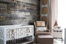 a farmhouse nursery design with a weathered wood wall, a modern crib with acrylic detailing, a pretty white chest and a gallery wall