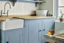 a spatel blue kitchen with light-colored butcher block countertops that add a natural touch to the space