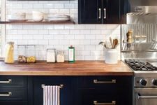 black cabinets with brass handles look great with butcher block countertops that soften the space