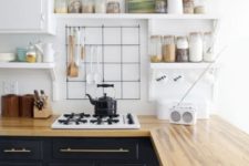 retro-inspired black cabinets with light-colored butcher block countertops that soften the monochromatic kitchen