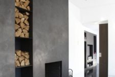 04 a dark concrete clad fireplace with open firewood storage built-in for a Nordic or minimalist space