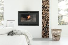05 a minimalist all-white nook with a built-in fireplace and built-in firewood storage plus pillows looks heavenly and welcoming