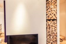 07 a minimalist built-in fireplace with built-in firewood storage next to it plus an additional felt bag with firewood