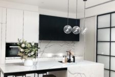 07 a minimalist contrasting kitchen with black and white cabinets, a white marble tile backsplash and kitchen island plus pendant lamps