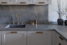 09 a minimalist light grey kitchen with chic grey marble countertops and a backsplash plus brass details for a refined feel
