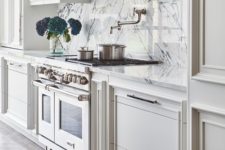 14 a stylish farmhouse vintage kitchen in neutral shades, with a white marble backsplash and a vintage hood and cooker