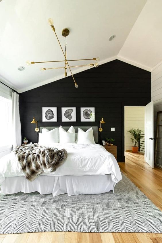 a stylish modern farmhouse bedroom with a black shiplap accent wall and all neutrals around plus gold for a chic touch