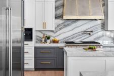 18 an art deco kitchen with grey and white cabinets, a metal hood, touches of gold and white marble countertops and a backsplash