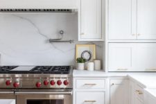 20 an elegant white kitchen with chic cabinets, gold touches and a white marble backsplash for a refined touch