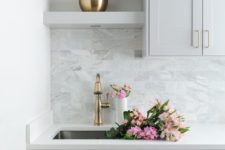 23 a grey farmhouse kitchen with a white countertop and a grey marble tile backsplash plus some touches of gold