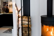 24 a modern wood stove and a wall-mounted firewood rack plus a branch with lights to make the space cooler