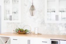 24 a neutral farmhouse kitchen with white cabinets, a wooden countertop and a marble tile backsplash plus a catchy pendant lamp